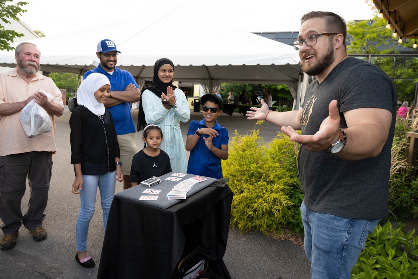 Children and grown-ups enjoying close-up magic with Chris Wheel